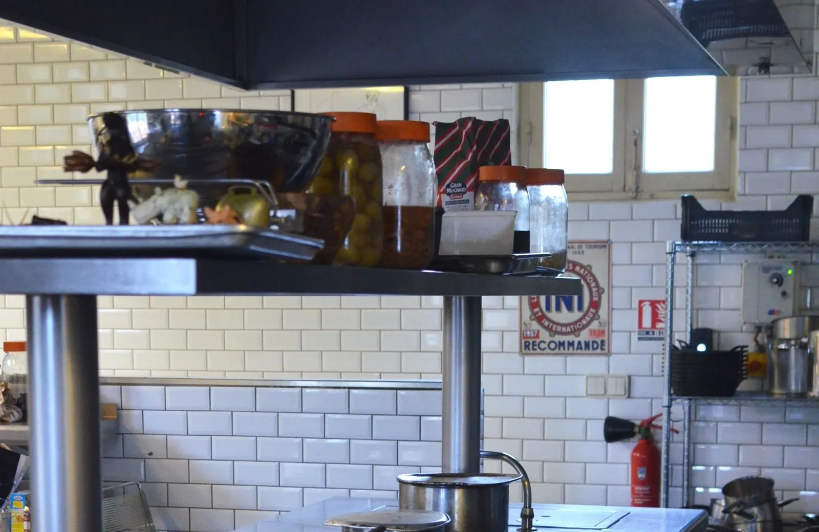 Un plan de travail en inox de cuisine professionnelle, casseroles posées